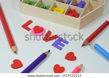 LOVE Wording, A Wooden Box Organiser And Colour Pencils Isolated with White Background 