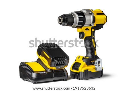 Yellow-black cordless Combi Drill Driver Hammer Drill and extra battery with charger isolated on white background. Royalty-Free Stock Photo #1919523632