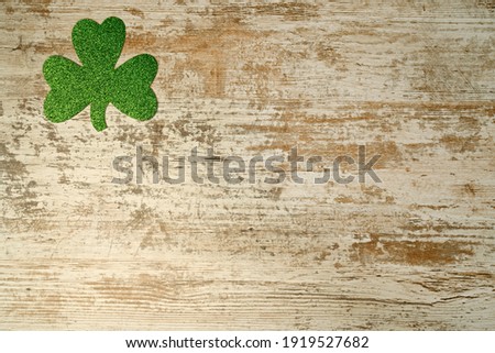 Concept of St. Patrick. Green clover on wood background, top view place for text.