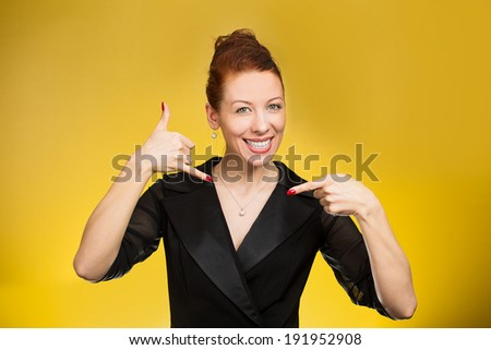 Closeup portrait young single business woman, happy student, worker making call me gesture, sign with hand shaped like phone, isolated yellow background. Positive human emotions, face expressions