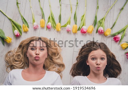 Top above high angle view photo of mother and daughter lie floor send air kiss flowers tulips indoors inside house