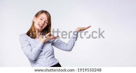 Banner- format long, portrait of a beautiful, young, smiling modern woman in casual clothes who points her fingers at something.