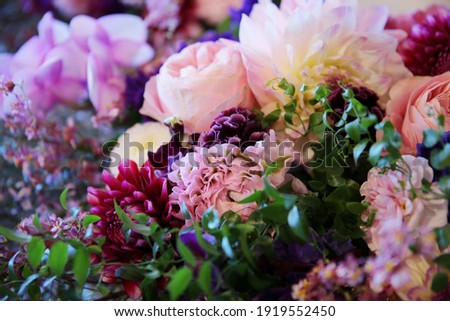Flower arrangement of pink roses, mauve and purple dahlia flowers