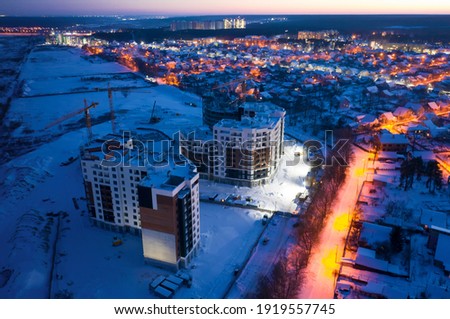 Night cityscape. Construction site on the outskirts of the city. Construction of a multi-storey residential complex on the outskirts of the city.