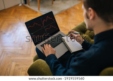 Trading stocks for beginners. Man using laptop for stock market. Crypto stock exchange. Investment business graph traders concept. Work from home back view of employee analyzing graphs Royalty-Free Stock Photo #1919559560