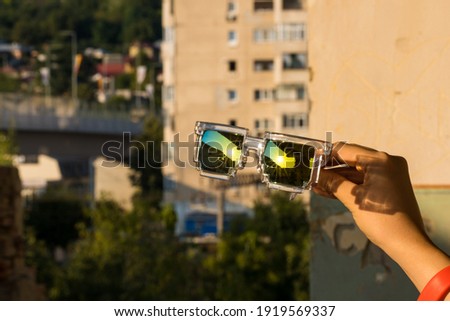 Pixel Model sunglasses hold in hand closeup in a sunny day. Selective focus