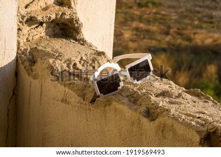 White pixel sunglasses with black lenses closeup in a sunny day. Selective focus