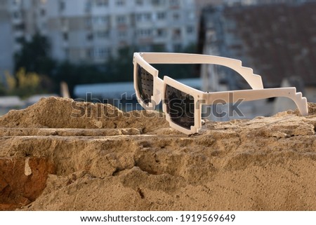 White pixel sunglasses with black lenses closeup in a sunny day. Selective focus