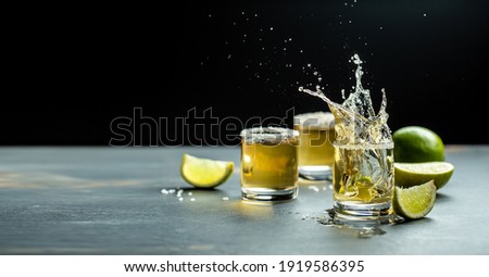 Mexican tequila with lime and salt on stone background. concept luxury drink. Alcoholic drink. Freeze motion, drops in liquid splash Mexican national drink. space for text. Royalty-Free Stock Photo #1919586395