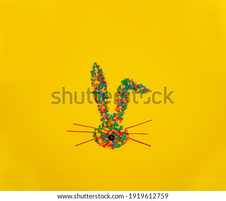 Happy Easter with colorful sweet candy heart shape bunny ears on bright yellow Background. Easter concept. Minimal concept. Springtime. Sweet candy concept. Flat lay. Copyspace for text. Easter banner