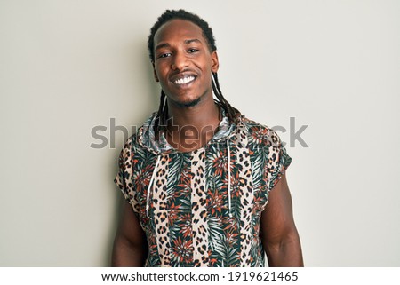 African american man with braids wearing fashion modern shirt with a happy and cool smile on face. lucky person. 