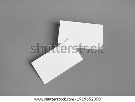Mockup of blank business cards on gray paper background.