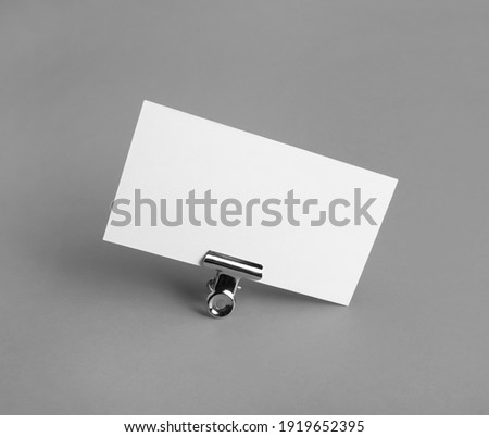 Photo of blank business card on gray paper background. Blank template for ID. Mockup for branding identity.