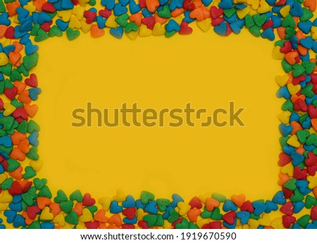  Colorful heart shape sweet candy frame on bright yellow background. Happy birthday greeting card. Holiday background. Sweet candy concept. Flat lay. Holiday Banner. Copy space for text. Love concept.