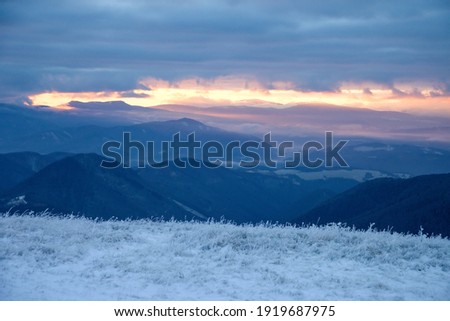 Sunrise above the Polana mountains and under heavy grey clouds, photo taken from Low Tatras mountains, Slovakia