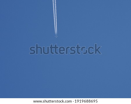 The plane is flying down and leaving traces of a line against the clear blue sky, copy space. Colorful picture with air transport