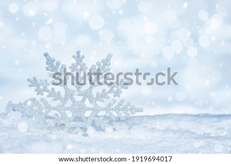 Beautiful decorative snowflake on white snow. Space for text