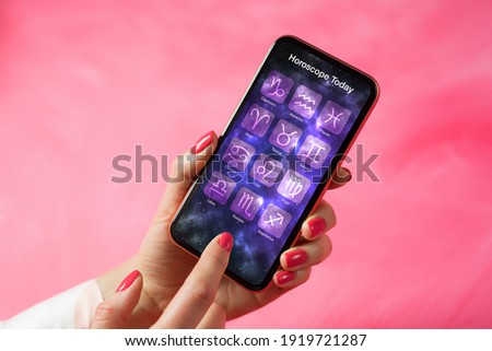 Person reading daily horoscope on mobile phone