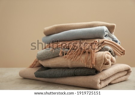 Stack of cashmere clothes on stone table Royalty-Free Stock Photo #1919725151