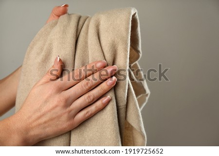 Woman with cashmere sweater on beige background, closeup Royalty-Free Stock Photo #1919725652