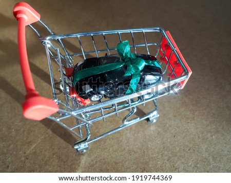 toy car tied with a ribbon as a gift in a miniature supermarket cart
