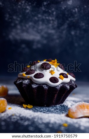 Delicious chocolate cake covered with glaze with additions of chocolate and tangerine
