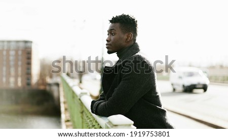 Contemplative African man looking at horizon wearing winter clothes