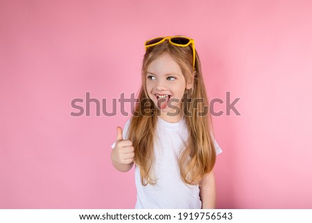 Child in sunglasses showing tongue showing cool