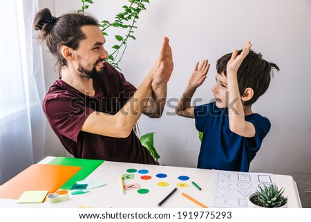 Happy autism boy during therapy with school tutor, learning and having fun together Royalty-Free Stock Photo #1919775293