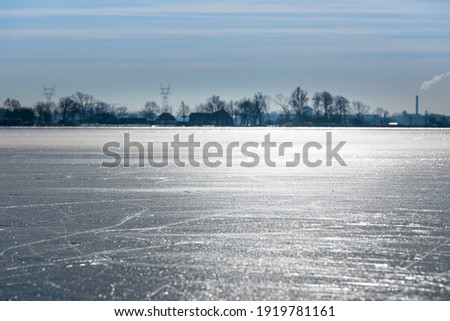 A winter landscape with shiny ice, across the frozen plains of the Kagerplassen in the south-holland municipality of Warmond in the Netherlands.