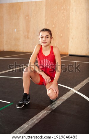 Female youth wrestler wearing a red singlet