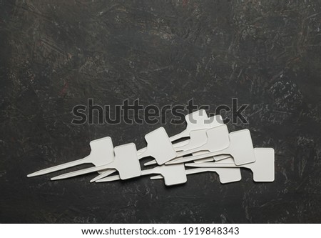 Collage of small white plastic signs on a dark background