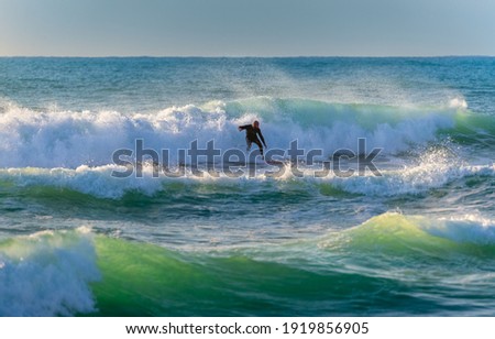 Surf. Picture of a Man Riding a Surfboard on the Crest of a Wave. Summertime Activity. Extreme Water Sport. Enjoying Summer Vacation on the Sea. 
