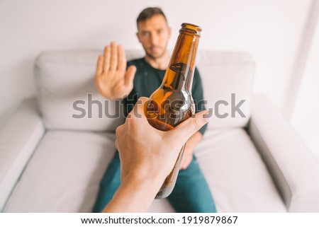 No alcohol. Young man refuses to drink beer. Stop drinking. Say no to alcoholism. Treatment of alcohol addiction Royalty-Free Stock Photo #1919879867