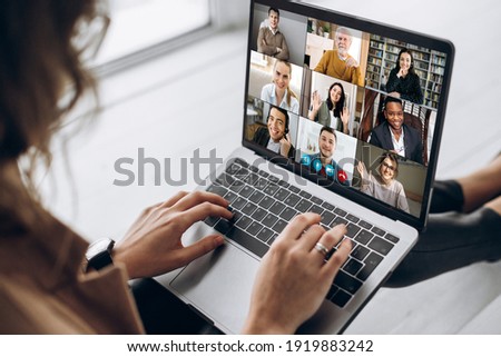 Back view of female employee communicate on video call with multiracial colleagues, woman worker conducts webcam group conference with business partners uses laptop and app Royalty-Free Stock Photo #1919883242