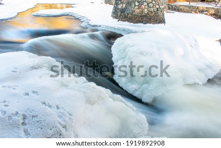 Water flowing under a bridge in northern Wisconsin. Royalty-Free Stock Photo #1919892908