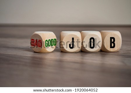 Cubes, dice or blocks with messages bad job and good job on wooden background