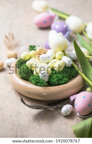 Easter composition with colorful Easter eggs and spring flowers  tulips on concrete background. Easter card  copy space