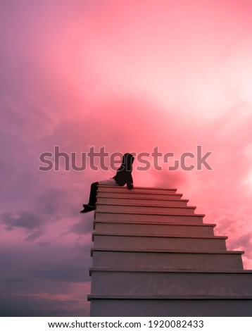 Silhouette of A man standing on the staircase at the beautiful sunset