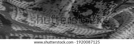 gray monochrome fabric with snakeskin pattern, background texture of bright gray fabric close up. background, texture, pattern