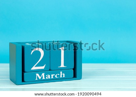wooden calendar with the date of 
March 21 on a blue wooden background, World Poetry Day; International Day for the Elimination of Racial Discrimination; International Day of the Puppeteer; 