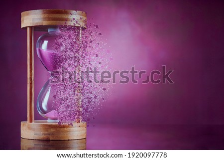 Dissolving hourglass on vintage background