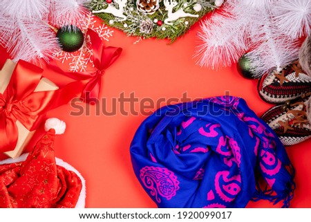 Minimalistic stylish background for design free space on a red background Christmas and New Year wreaths and toys, multicolored silk scarves