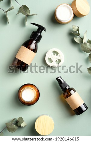 SPA natural cosmetics set on green background. Skincare beauty products and eucalyptus leaves top view.