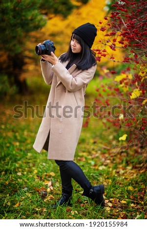 beautiful girl photographer in autumn park