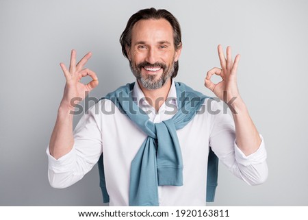 Photo of charming mature guy dressed white shirt pullover shoulders showing okey sign two arms hands isolated grey color background