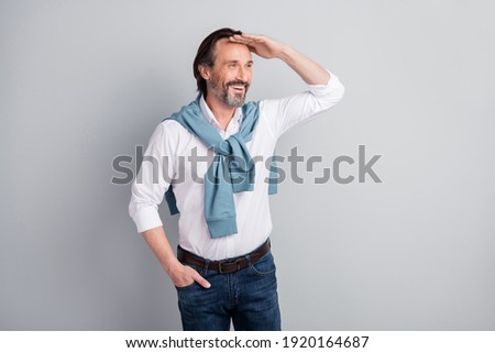 Photo of attentive funny mature guy dressed white shirt pullover shoulders looking far away arm hand head isolated grey color background