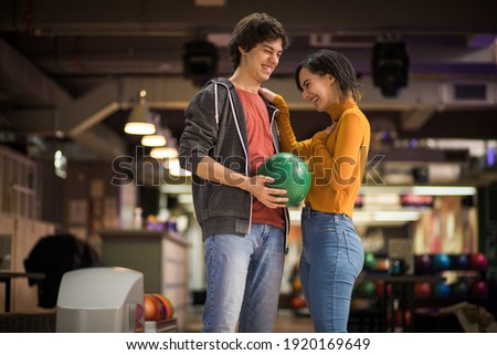 Young couple having fun in bowling alley. 