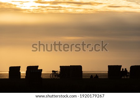Beach baskets in in front of sunset. Dorum-Neufeld in Lower Saxony in Germany