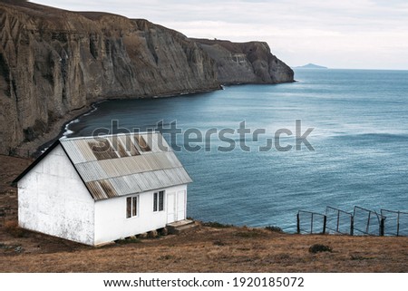 White house on the beach. A lonely house on a promontory by the sea. Seascape. An old abandoned house by the sea. Copy space Royalty-Free Stock Photo #1920185072